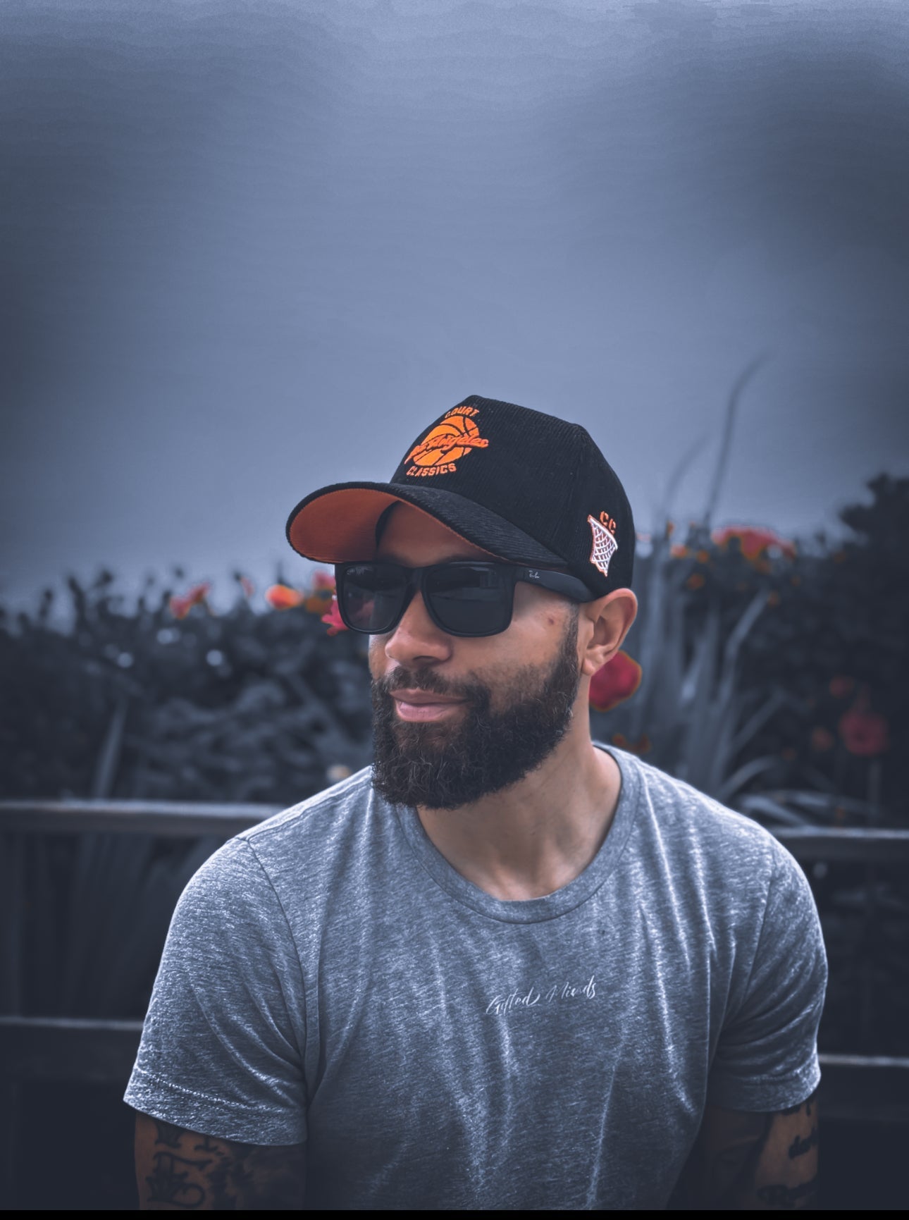 Model wearing black & orange corduroy snapback hat outdoors with palm trees – Court Classics