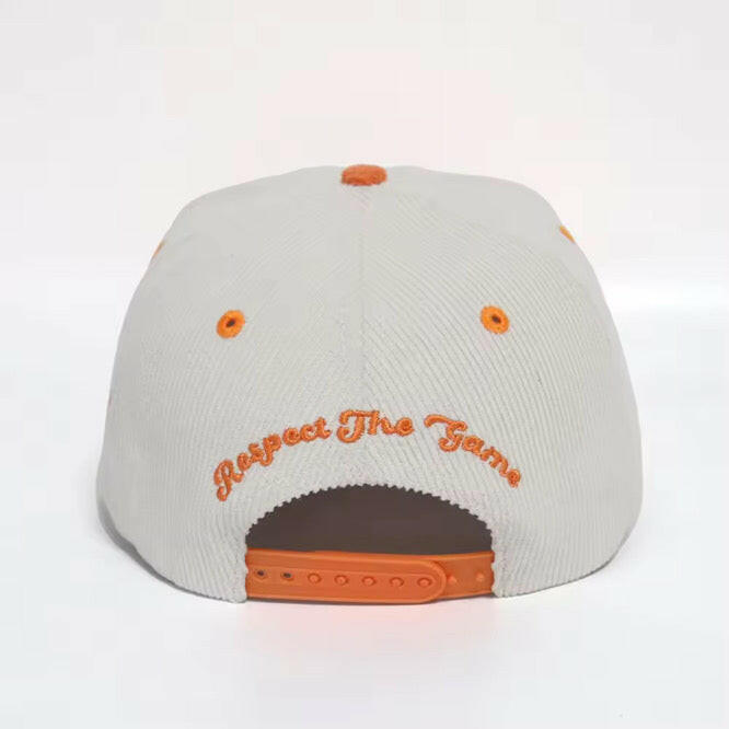 Back view of white & orange corduroy snapback hat with Respect the Game embroidery and adjustable snapback strap
