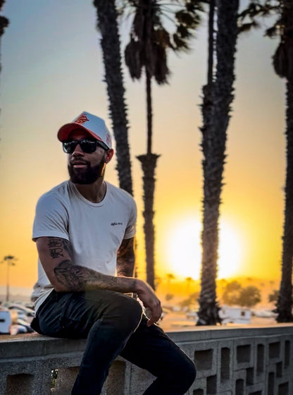 Model wearing white & orange corduroy snapback hat at sunset with palm trees – Court Classics