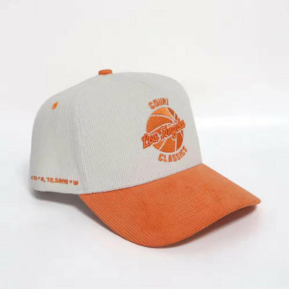 Angled view of white & orange corduroy snapback hat with embroidered Los Angeles logo and side coordinates